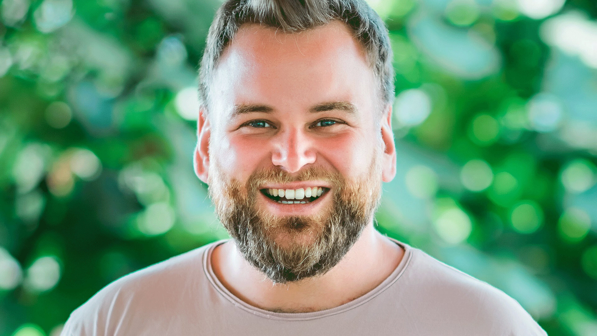 Ein Portrait vom Künstler Andre Haedicke vor grünem Hintergrund