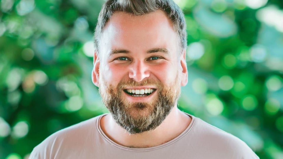 Ein Portrait vom Künstler Andre Haedicke vor grünem Hintergrund