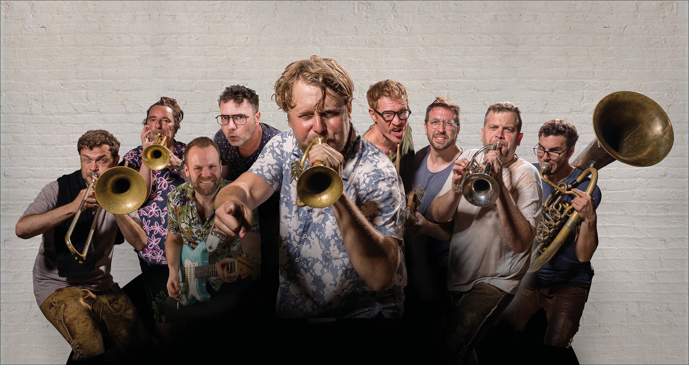 Foto der Gruppe mit Instrumenten und einer beigen Wand im Hintergrund