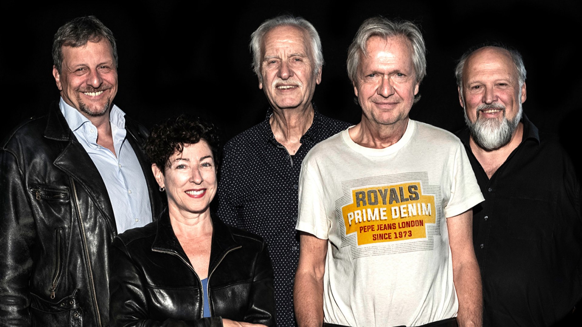 Vier Herren und eine Dame vor schwarzem Hintergrund