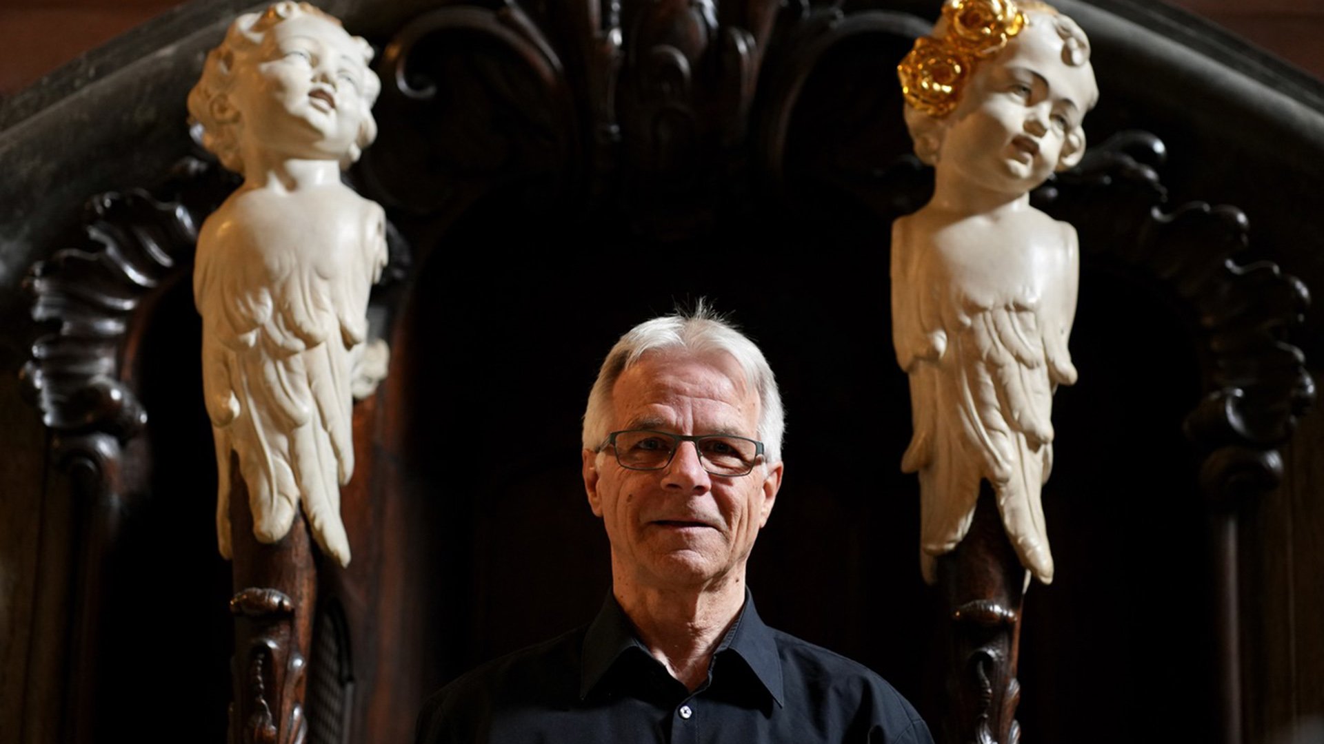 Stefan Moser im Zentrum zweier Engelsfiguren