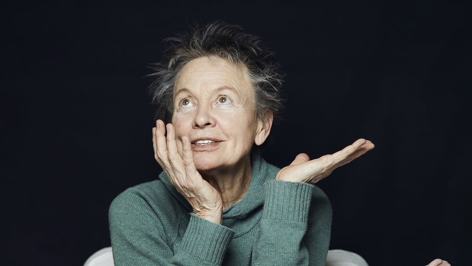 Foto von der Künstlerin Laurie Anderson mit Sexmob vor schwarzem Hintergrund