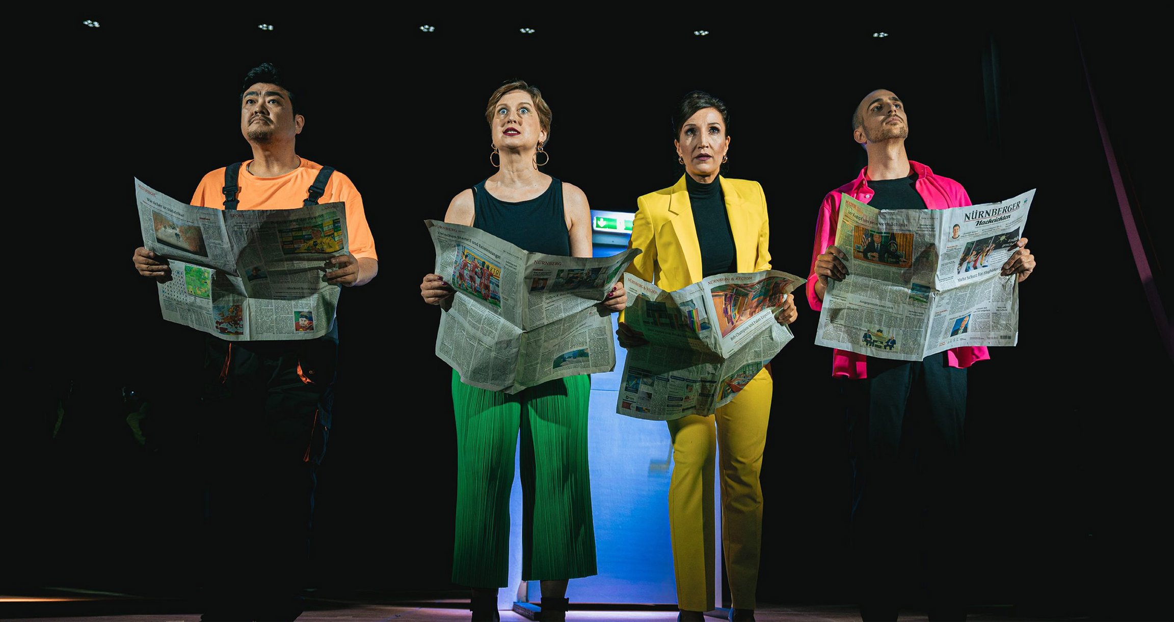Foto der Veranstaltung TAMTAM – Terz, Tenor, Theaterdonner mit vier Künstlern in bunten Kostümen, die Zeitungen in den Händen halten.