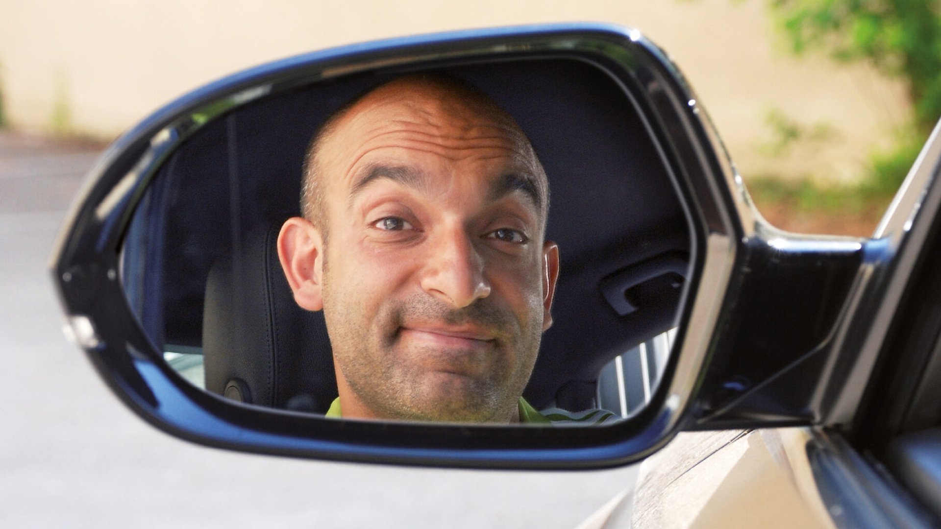 Der Künstler in einem Rückspiegel eines Autos