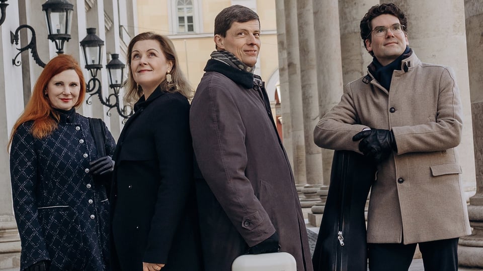 Foto für die Veranstaltung von Henschel Quartett & Hendrik Blumenroth mit den vier Mitgliedern in einer Straße zwischen Säulen und Laternen