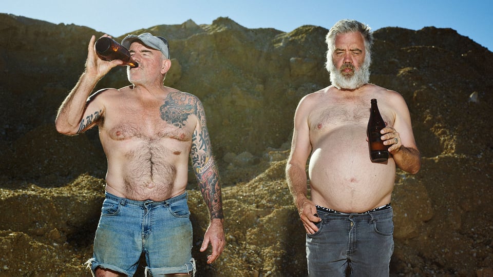 Foto für die Veranstaltung von Cosmic Psychos mit den beiden Künstlern draußen, oberkörperfrei, beim Biertrinken.