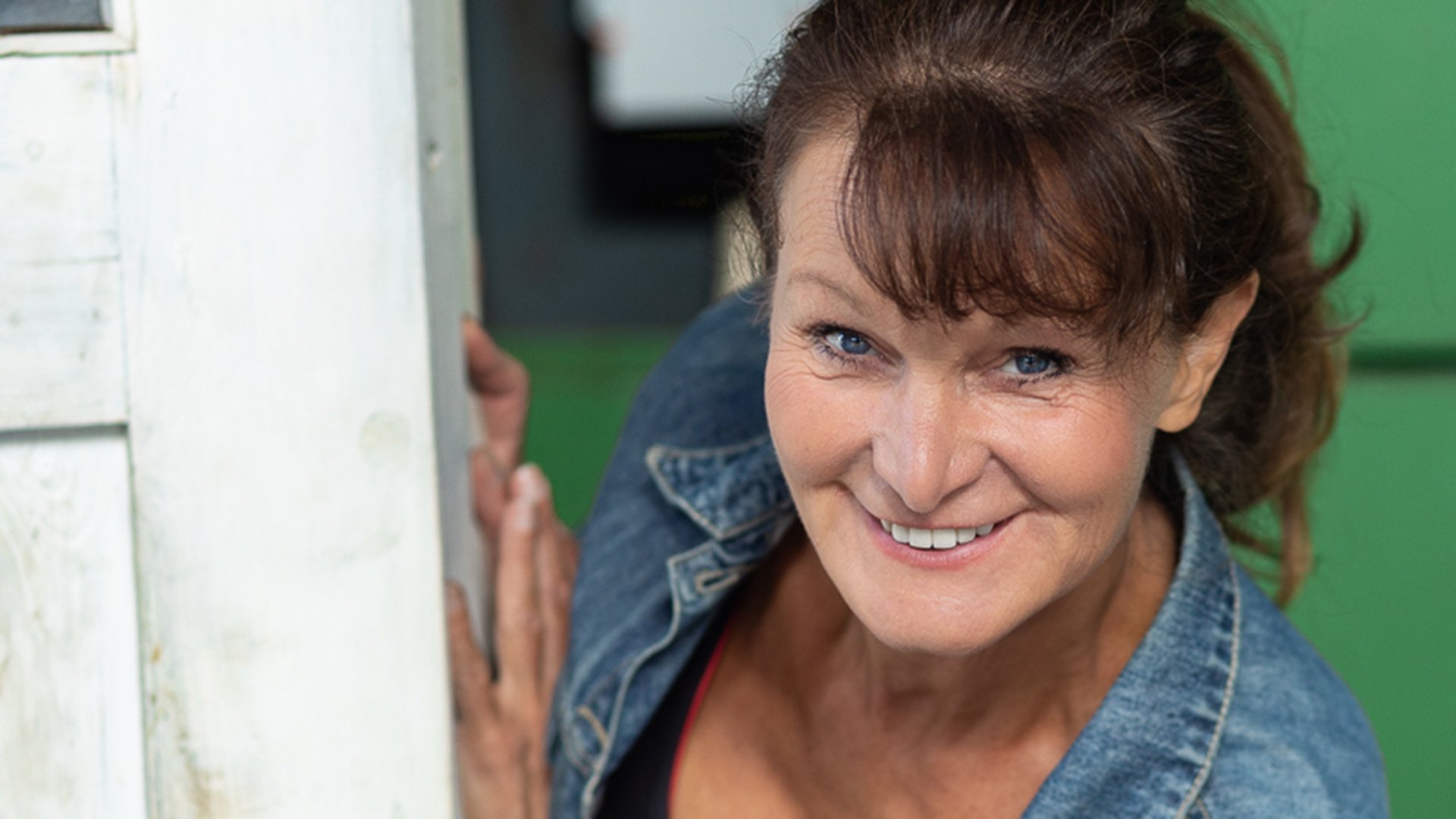 Porträt einer Person in Jeansjacke mit Blick zur Kamera, Nahaufnahme vor unscharfem Hintergrund, Pressebild für ein Kabarett- und Comedyprogramm.