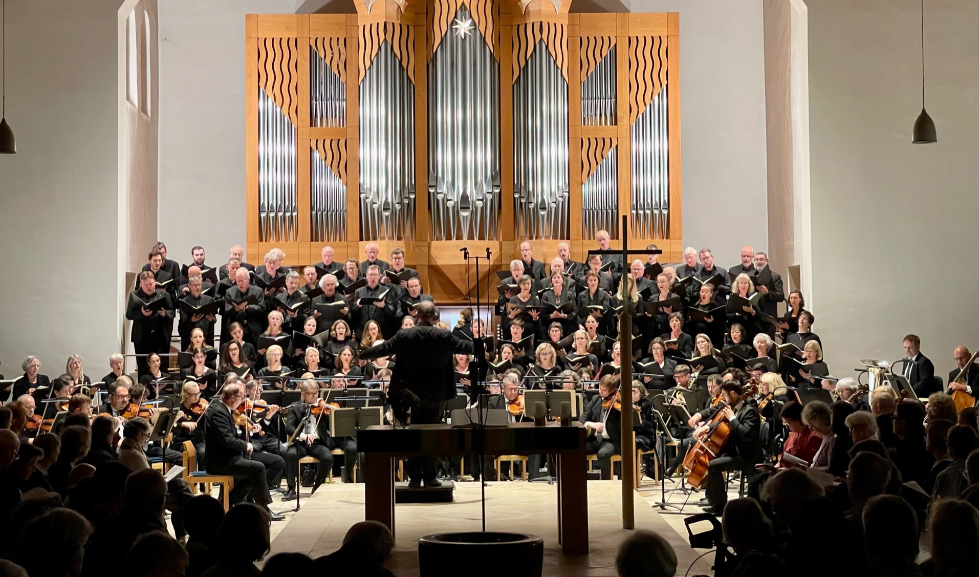 Foto von einem Orchester und im Hintergrund eine riesige Orgel