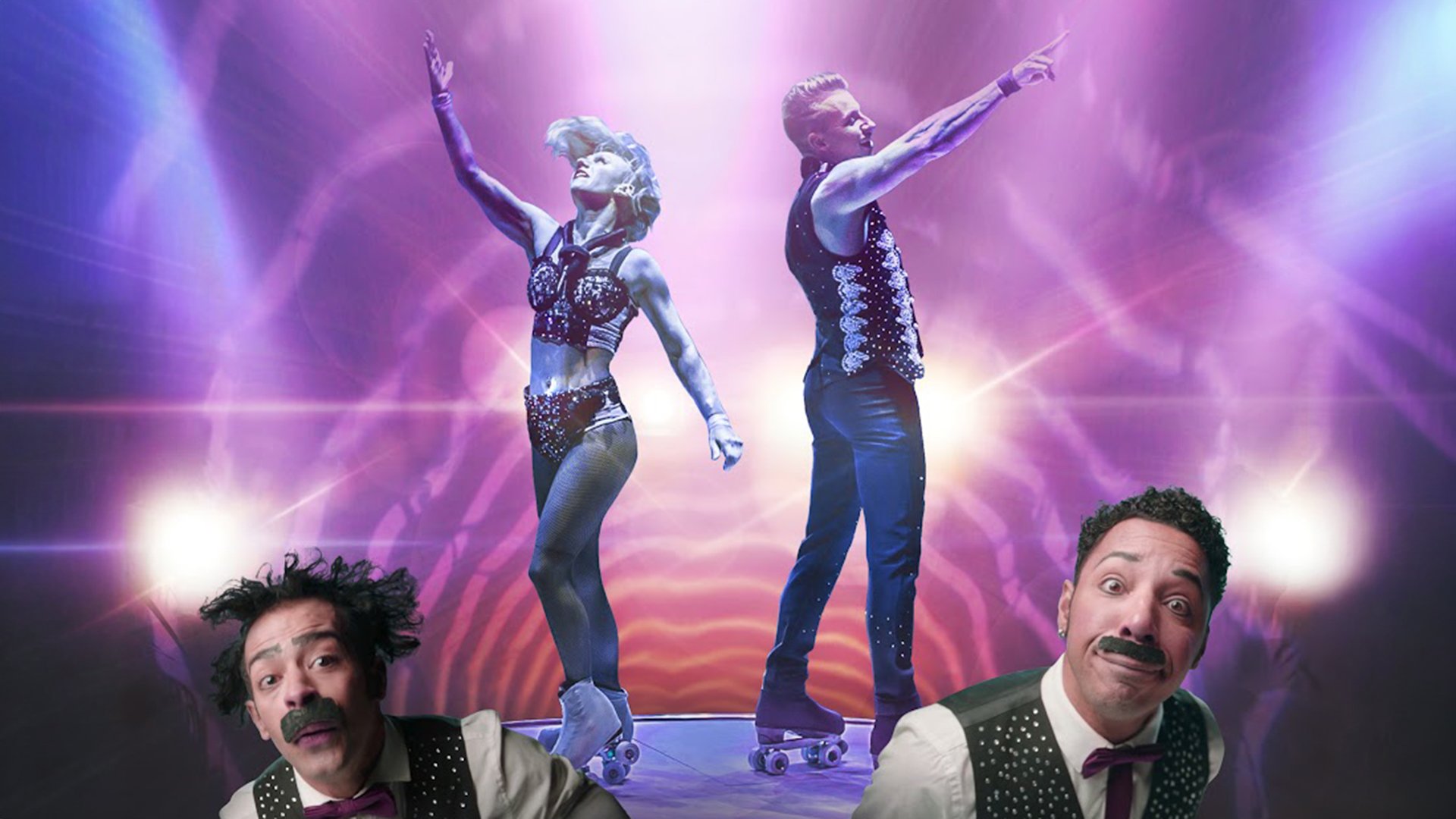 Zwei Artisten der Veranstaltungsreihe Hot Spot des GOP Theater posieren auf Rollschuhen auf einer beleuchteten Bühne mit violett‑pinkem Licht, im Vordergrund sind zwei weitere Showakteure