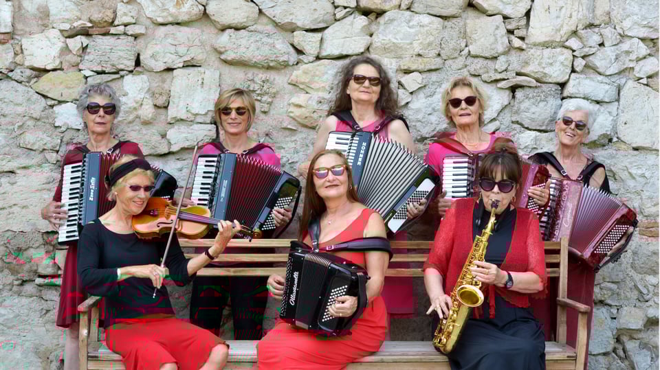 Ein Foto der acht Musikerinnen mit Instrumenten