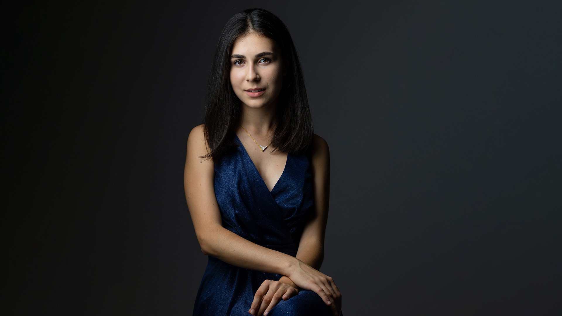 Porträt der Pianistin Alexandra Dovgan vor dunklem Hintergrund.