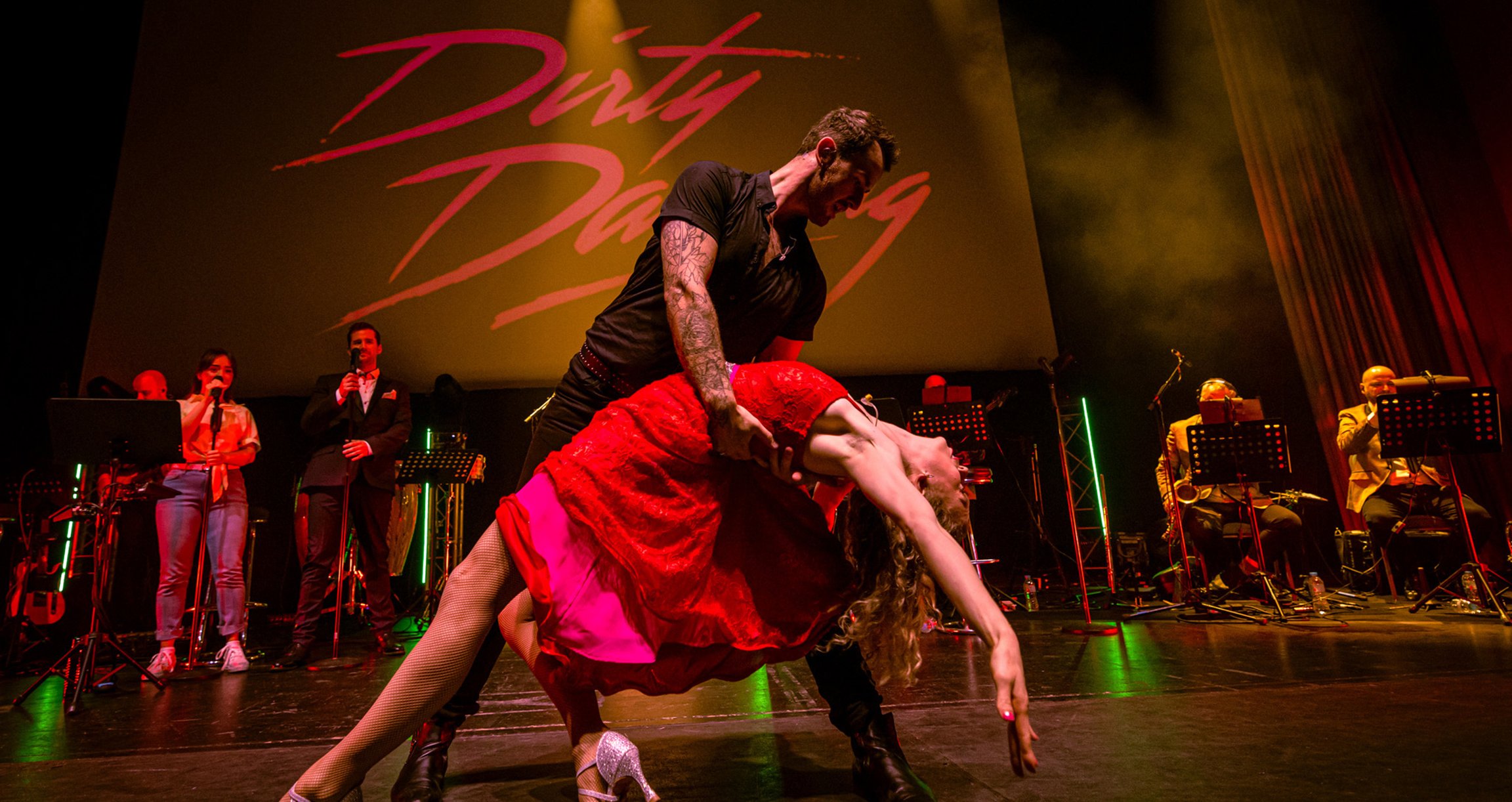 Foto der Bühne mit einem Mann und einer Frau, die „Dirty Dancing“ tanzen.