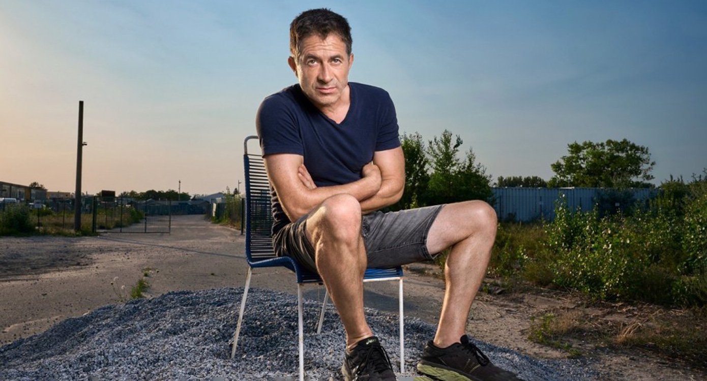 Mann mit kurzer Hose auf Stuhl im Freien sitzend