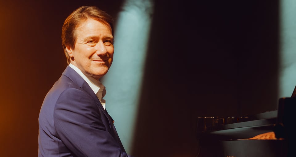 Foto des am Klavier sitzenden Künstlers