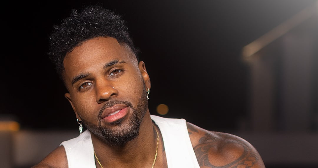 Auf dem Bild ist Jason Derulo vor einem schwarzem Hintergrund zu sehen.