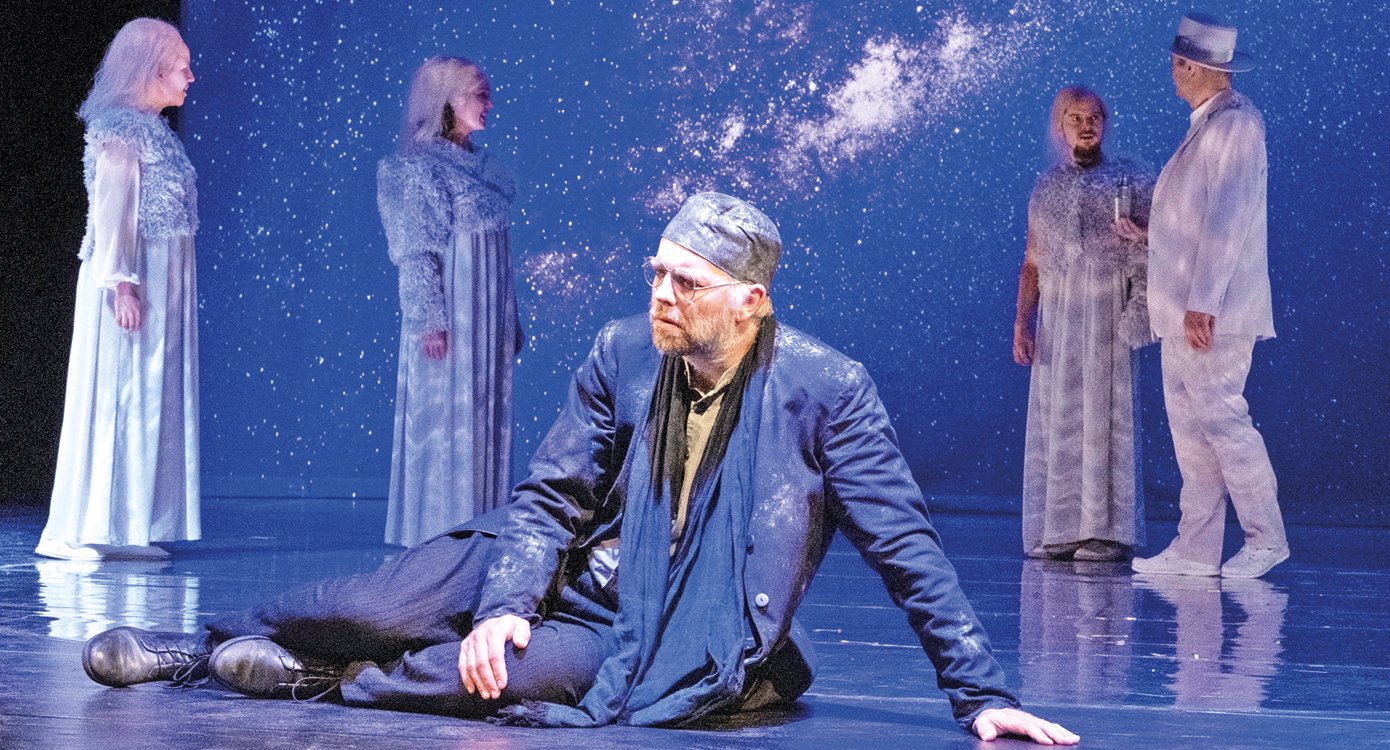 ein Foto der Bühne mit mehreren Schauspielern, von denen einer auf dem Boden liegt