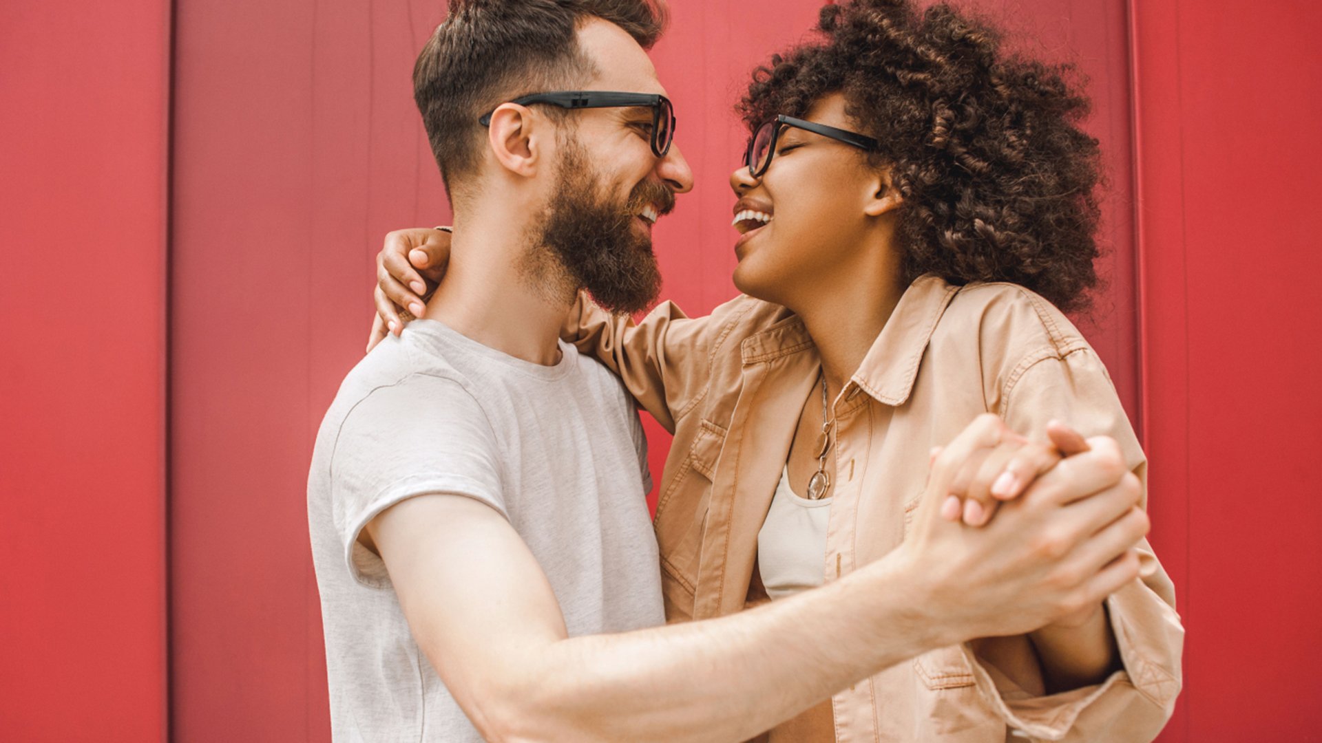 Ein Mann und eine Frau tanzen vor einer roten Holzwand