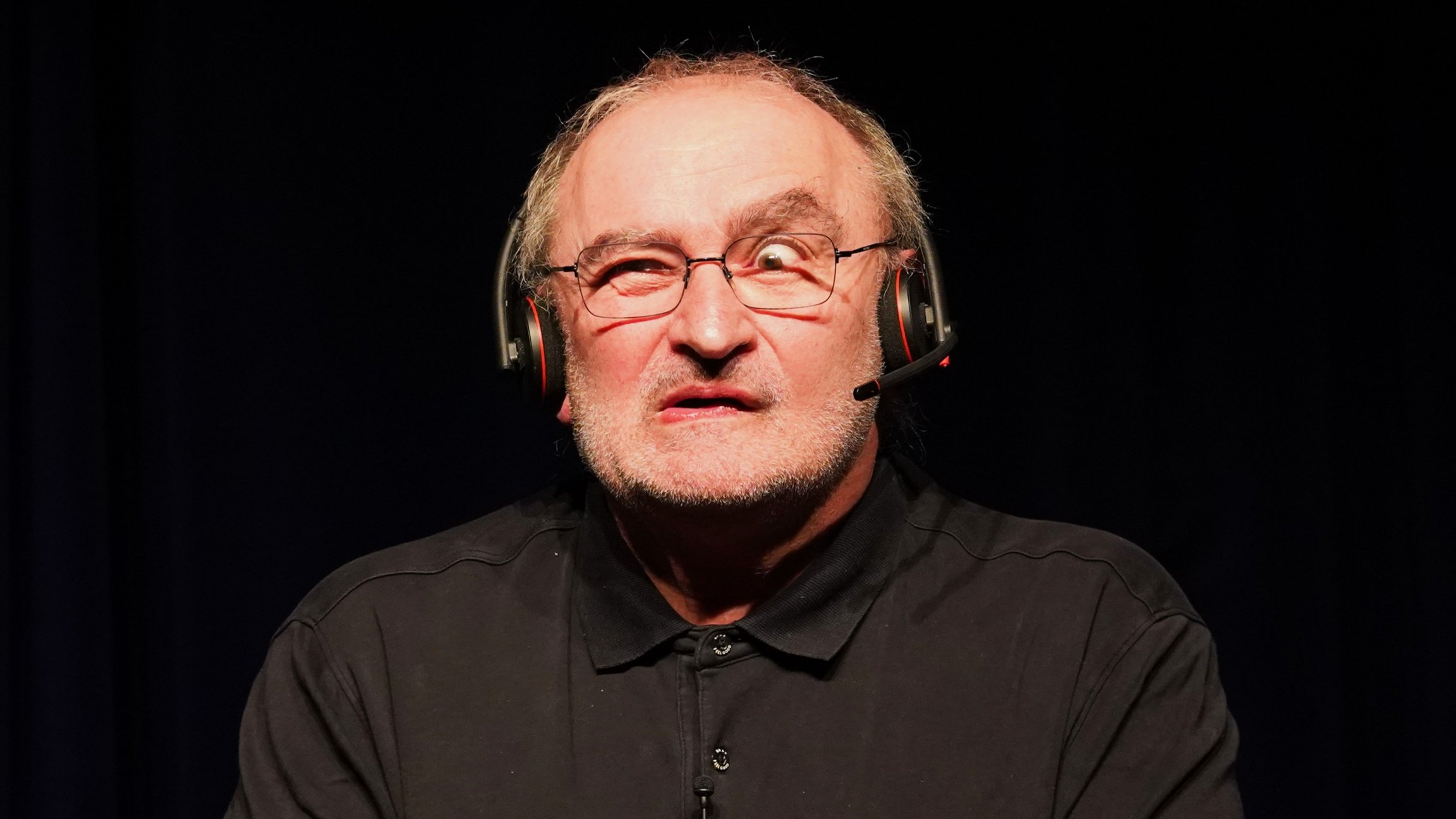 Siggi Zimmerschied mit Headset vor schwarzem Hintergrund