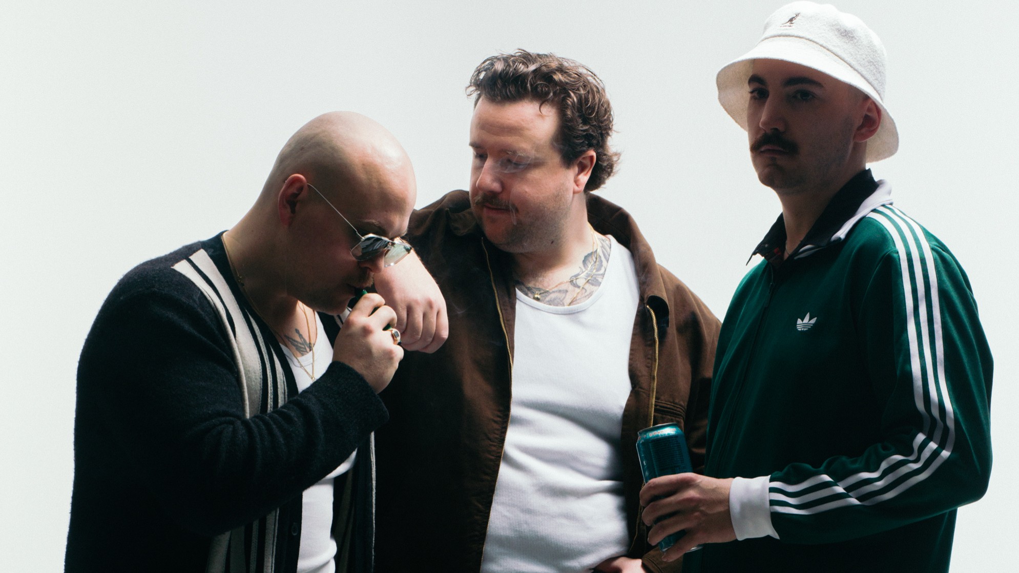 Drei Männer in Freizeitkleidung vor hellem Hintergrund