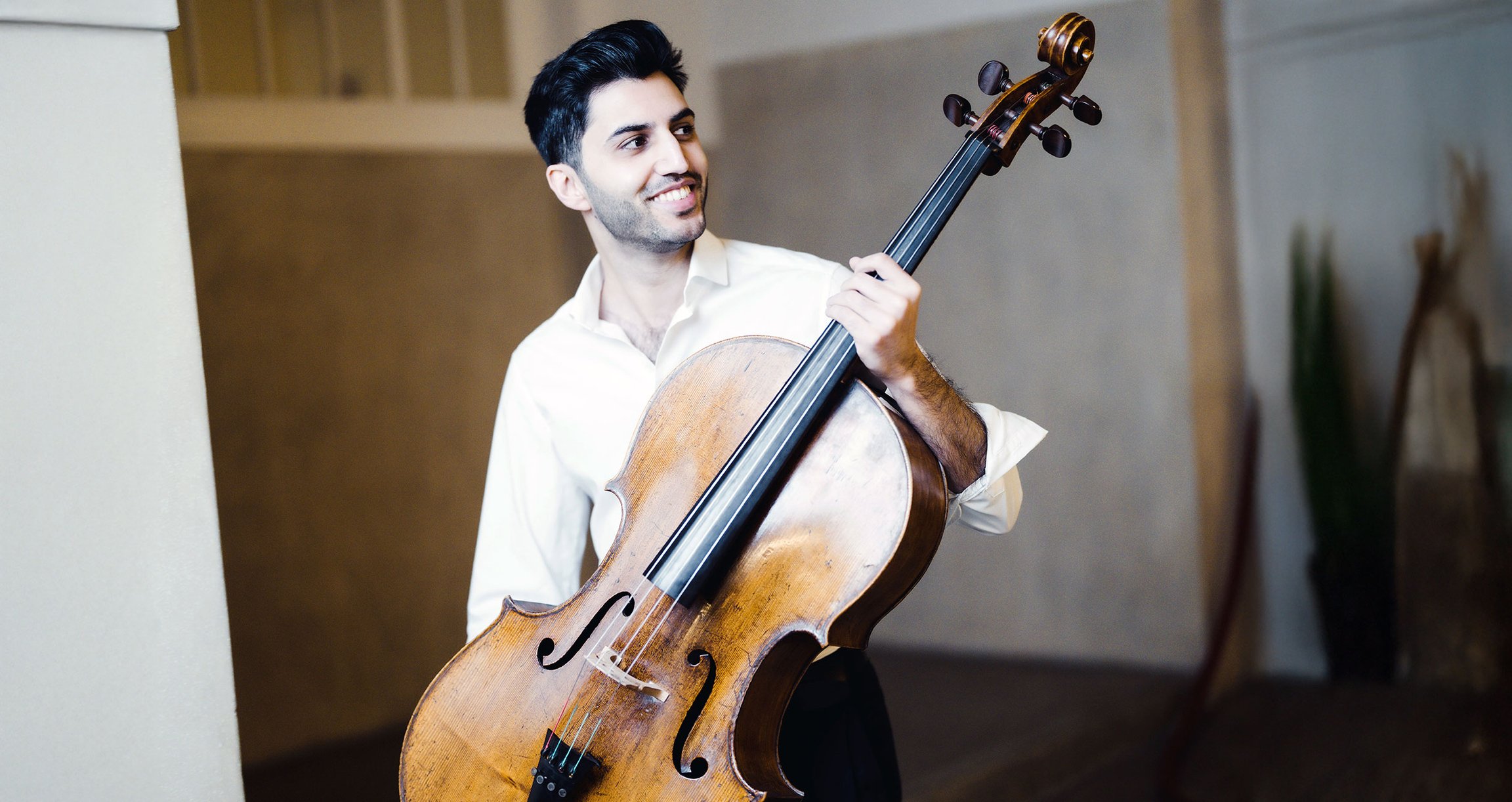 Kian Soltani lächelt mit seinem Instrument in der Hand