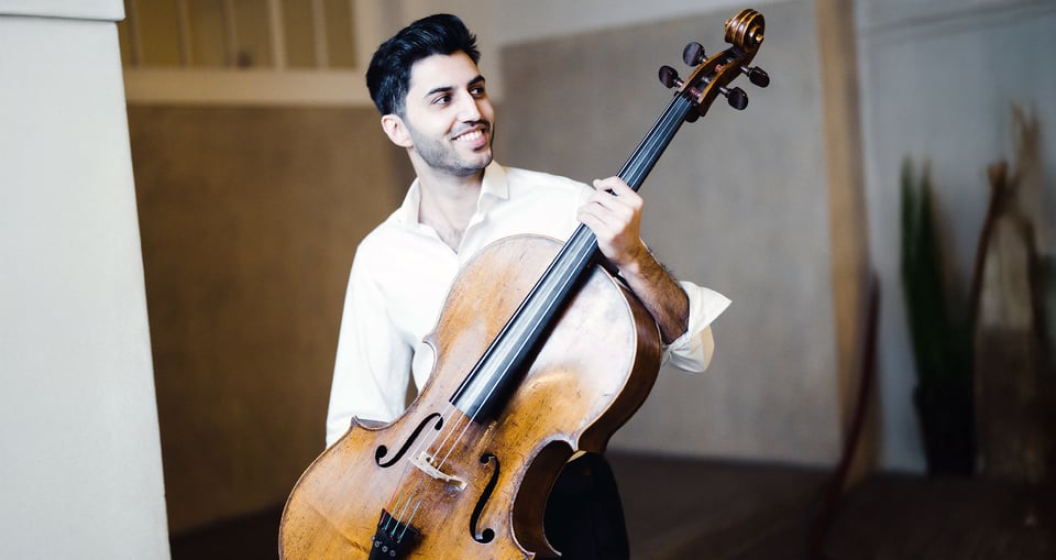Kian Soltani lächelt mit seinem Instrument in der Hand