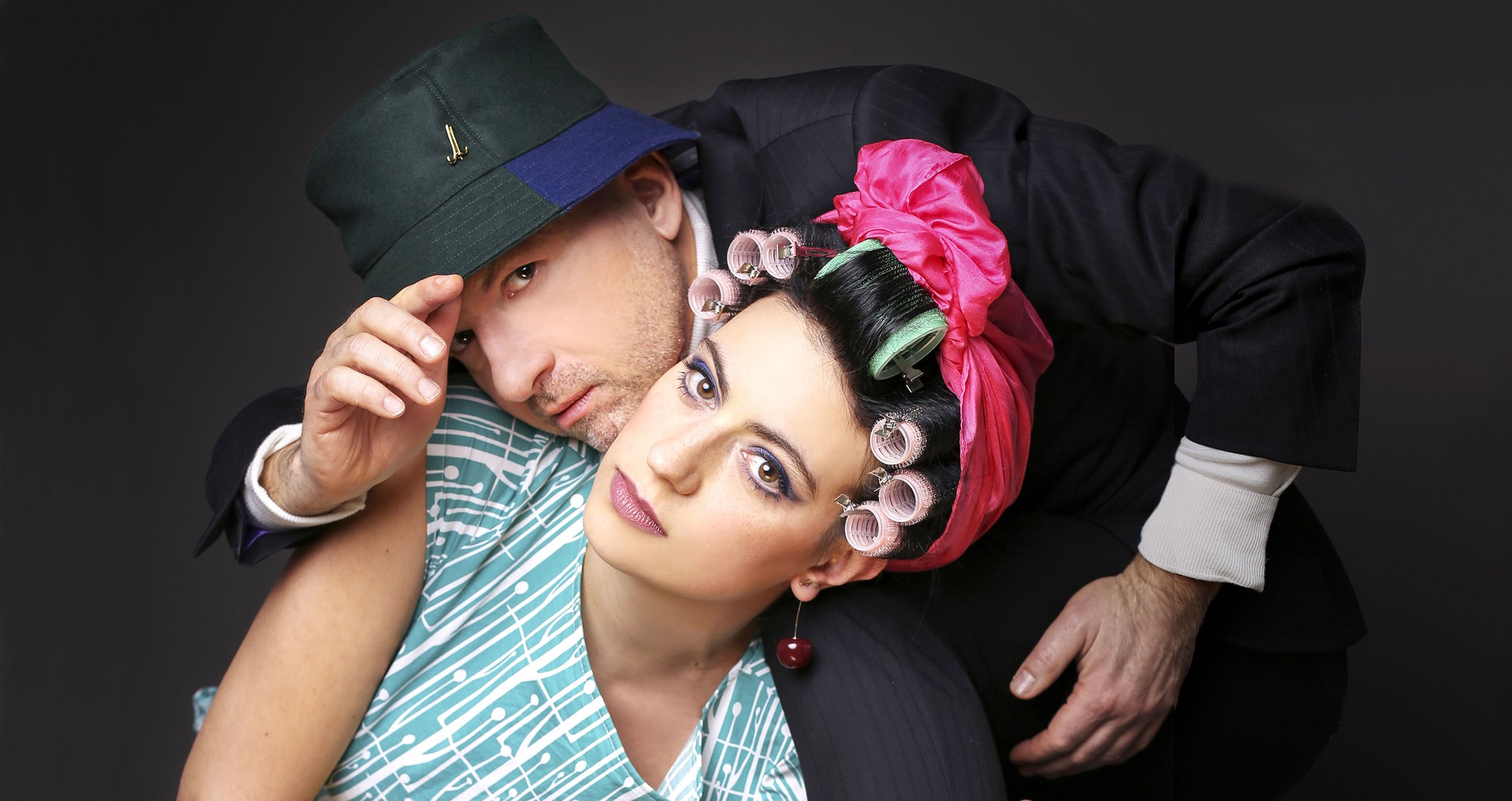 Foto der Künstler, er mit einem Hut und sie mit Locken auf dem Kopf