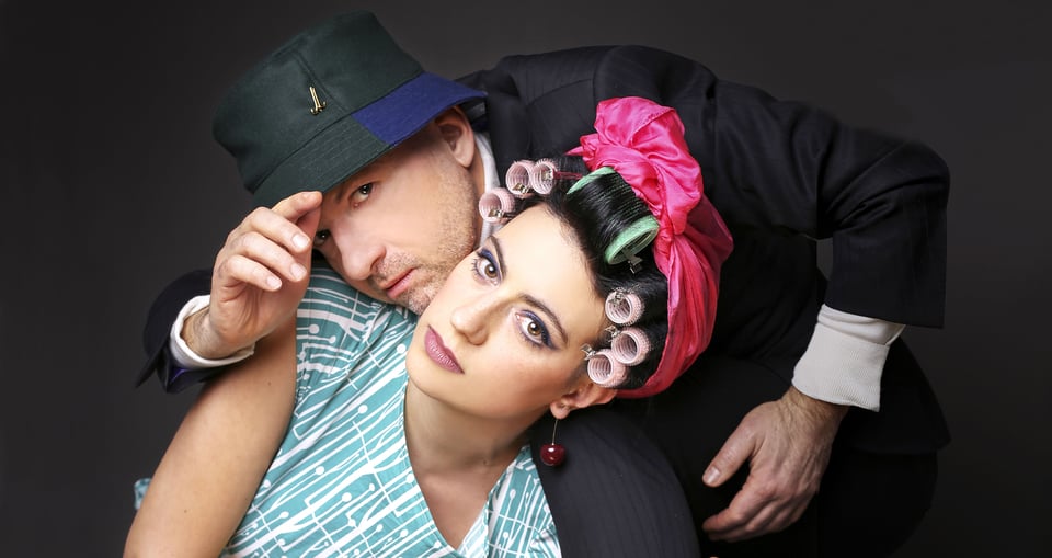 Foto der Künstler, er mit einem Hut und sie mit Locken auf dem Kopf