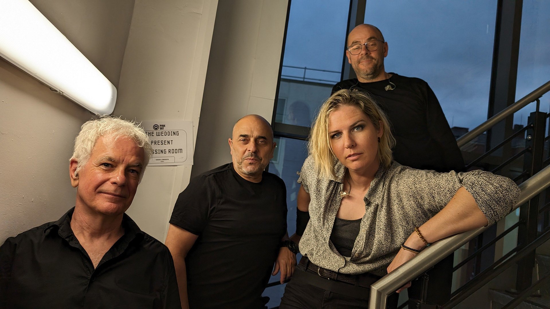 Foto für das Event ‚The Wedding Present‘, mit den Künstlern auf einer Treppe und einem Fenster im Hintergrund