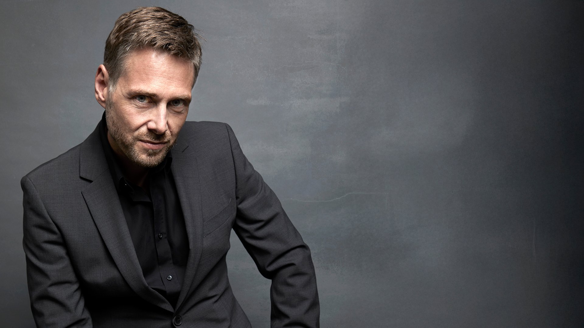 Foto für die Veranstaltung ‚Mozart-Soirée‘ – der Künstler Michael Nagy vor grauem Hintergrund