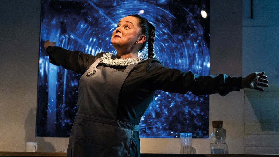 Foto für die Veranstaltung „Soloway 2026 – Squirrel, who has lived for 100 years“ mit einer Darstellerin in Dienstmädchenkostüm mit ausgebreiteten Armen.