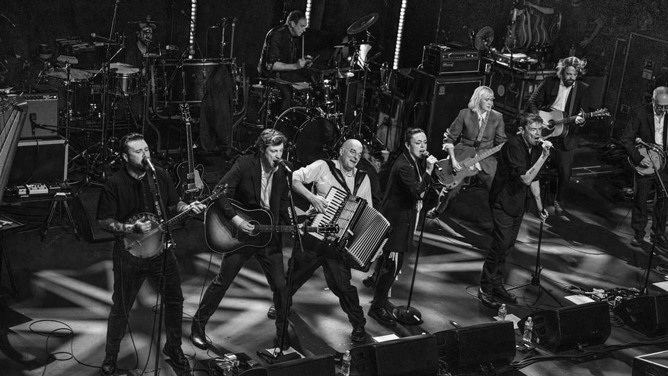 Die Band the Pogues mit Instrumenten auf der Bühne