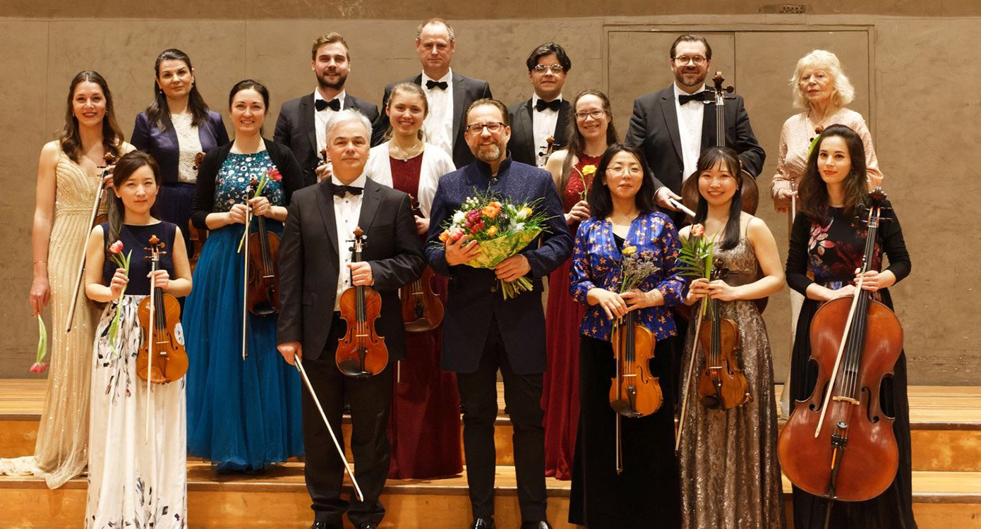 Orchester mit festlich gekleideten Künstlern und Instrumenten