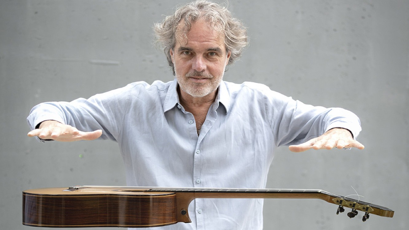 Der Künstler in weißem Hemd mit Gitarre