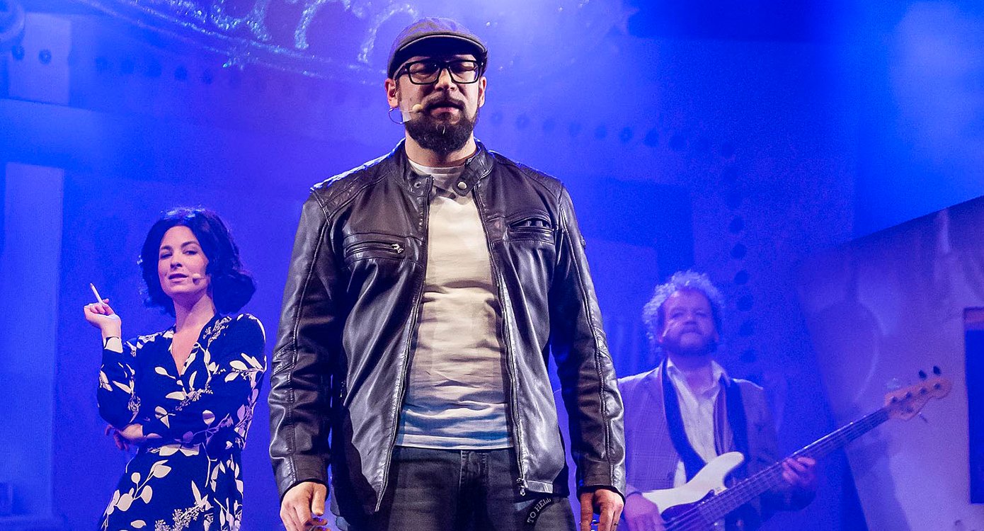 ein Foto des Stücks mit drei Schauspielern mit blauem Licht