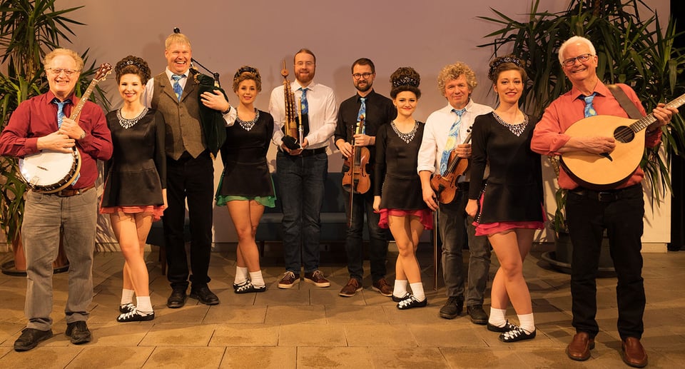 Eine Gruppe von Tänzerinnen und Musikern