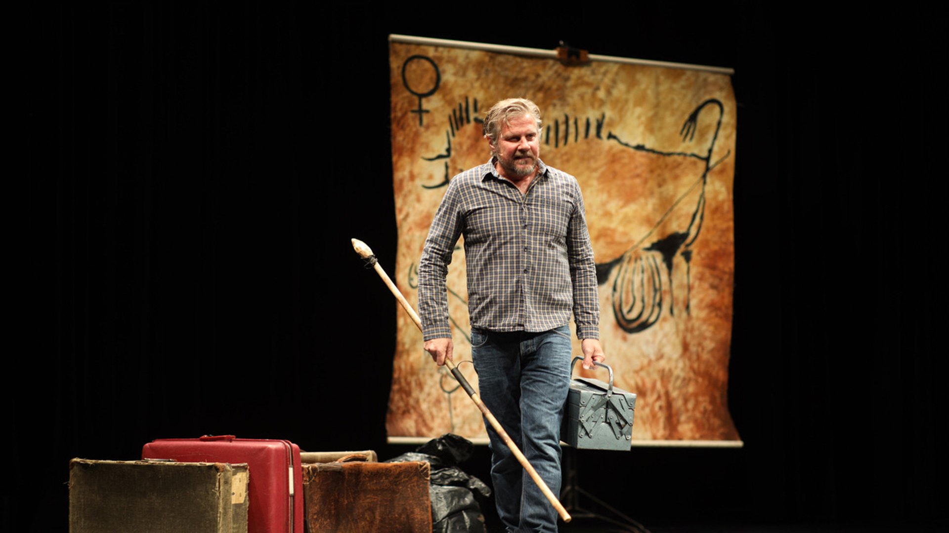 Foto für die Veranstaltung Caveman – ‚Du sammeln, ich jagen!‘ mit dem Künstler und einem Aktenkoffer in der Hand