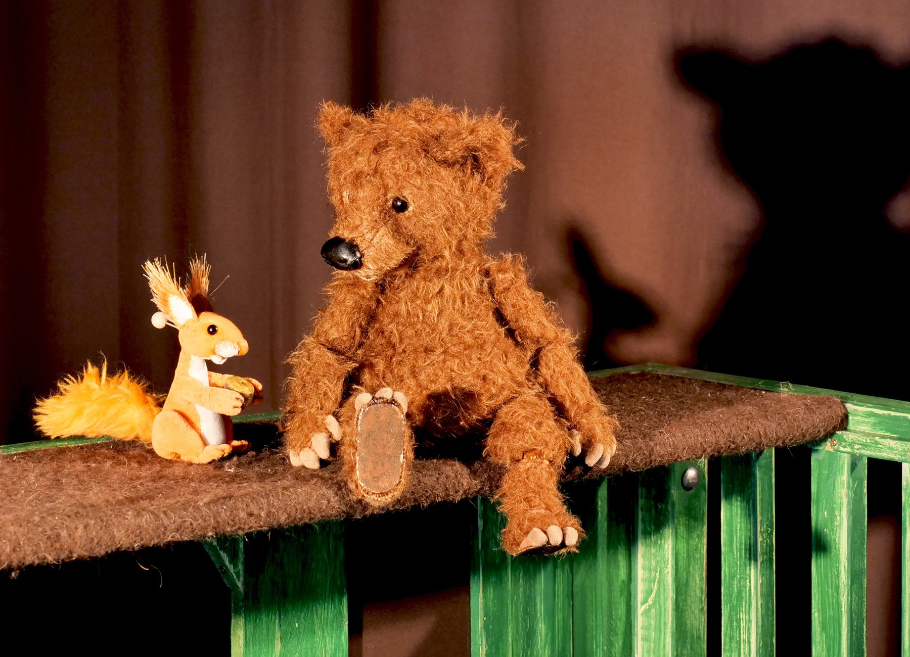 Stoffbär und Stoffhase auf Brett sitzend