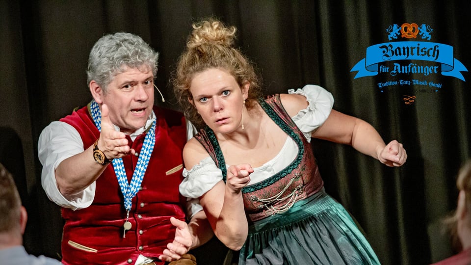 Foto für die Veranstaltung ‚Bayrisch für Anfänger – Comedy Dinner‘ mit einem Mann und einer Frau in traditioneller bayerischer Tracht