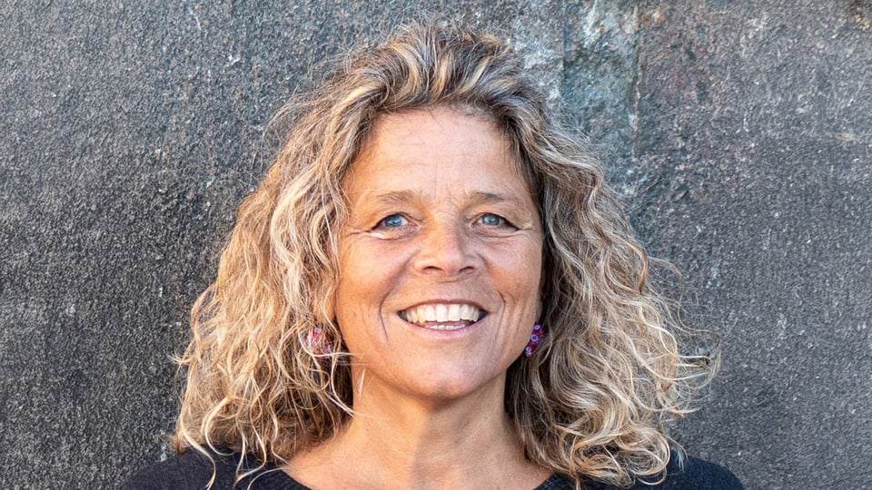 Foto für das Jodelkurs für Einsteiger*innen, mit einer blonden Frau vor einer Steinwand.