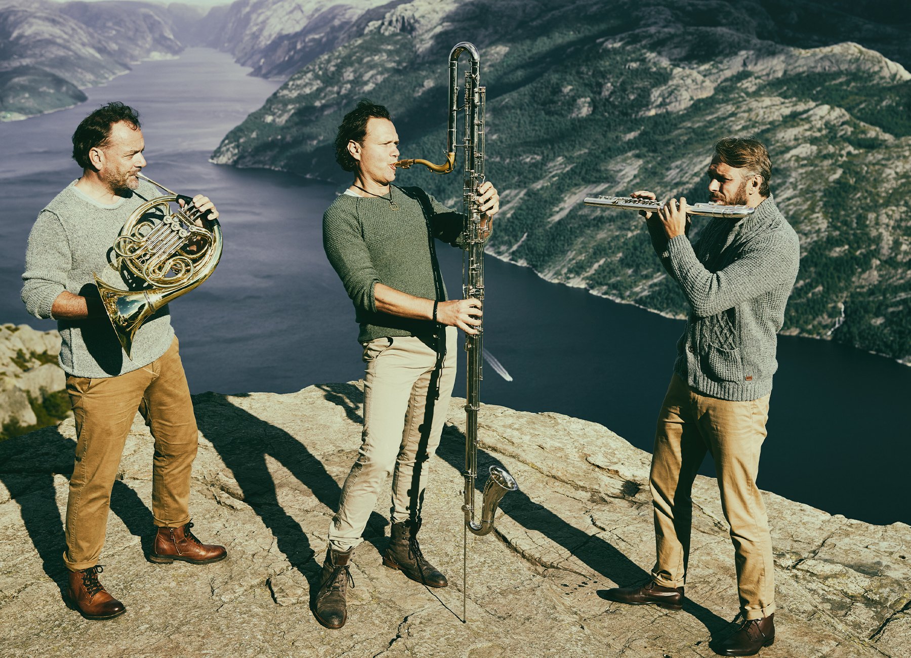 drei Männer die jeweils ein Instrument spielen