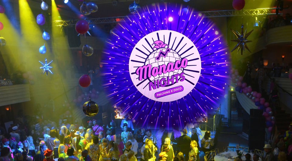 Plakat Monaco Nights mit großer runder Leuchtgrafik in Pink und Violett über einer Tanzfläche voller kostümierter Gäste, umgeben von Luftballons, Discokugeln und bunter Clubbeleuchtung, dazu der Schriftzug Monaco Nights – Fasching x Disco