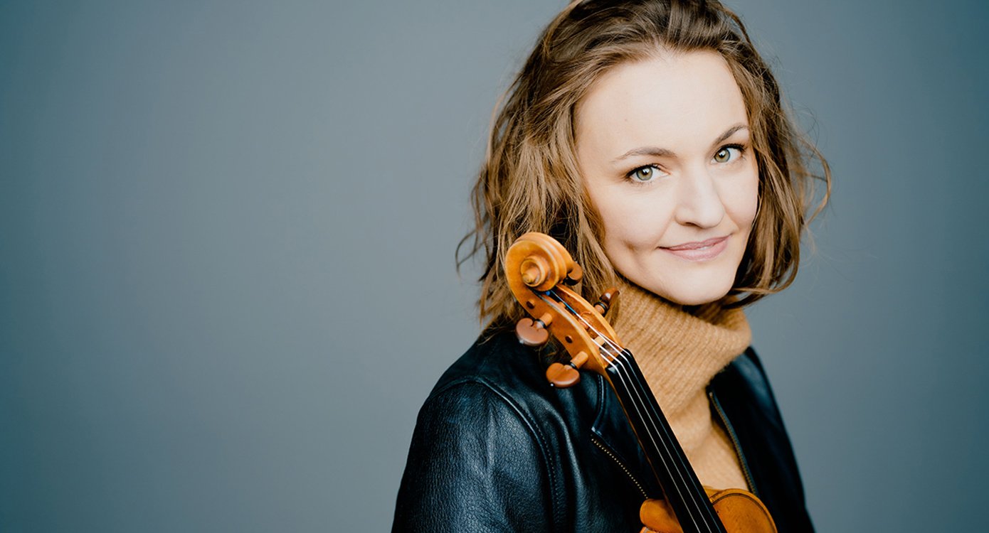 Foto der Künstlerin „Franziska Hölscher “, mit blauem Hintergrund und einem Instrument in ihrer Hand