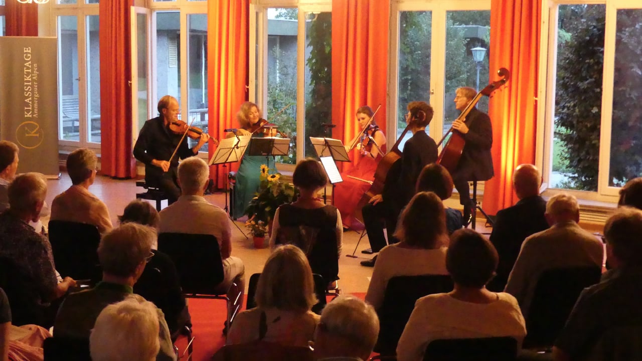 Kammerorchester auf Bühne mit INstrumenten und Publikum
