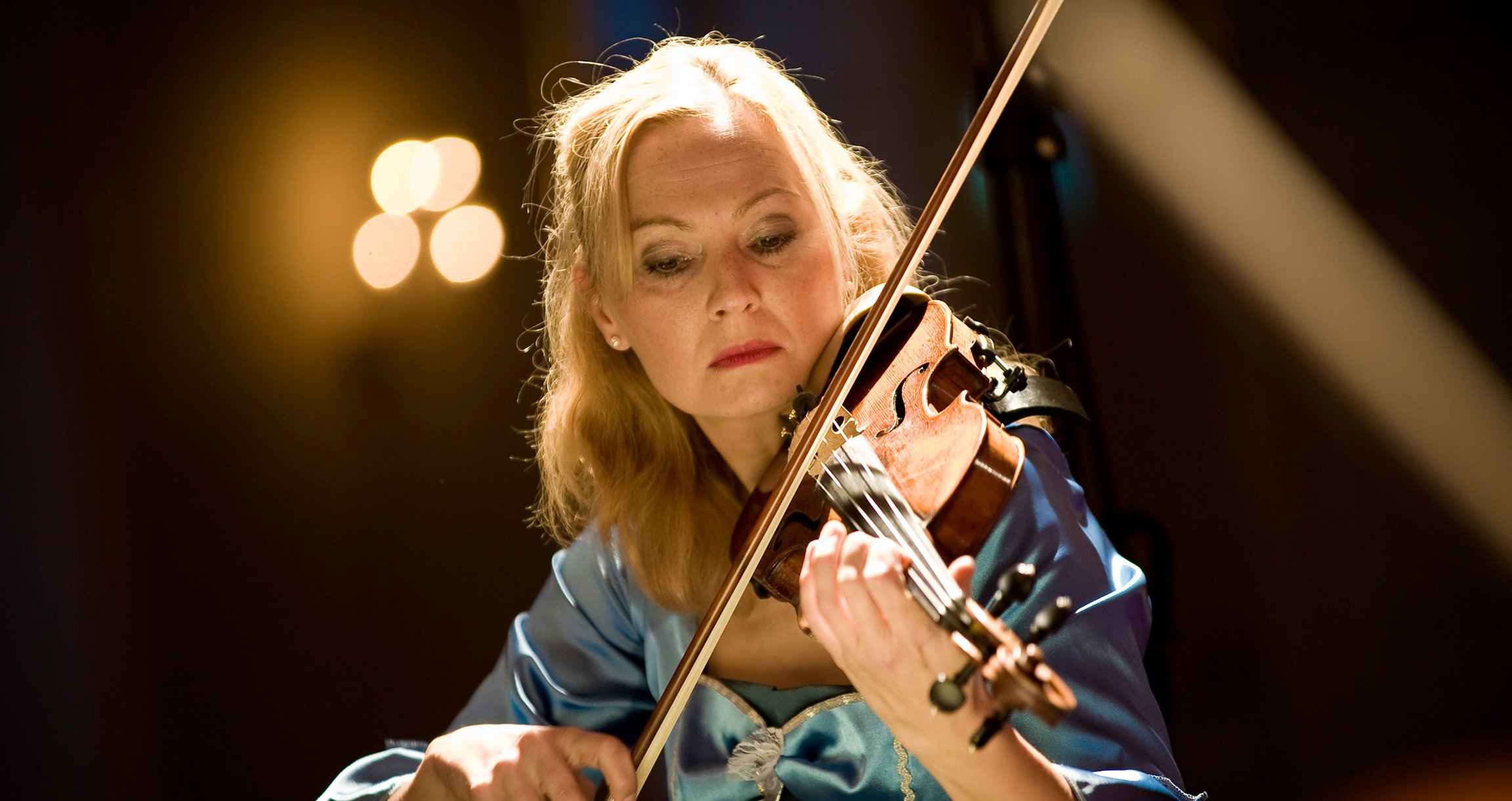eine Dame, die ein Saiteninstrument spielt