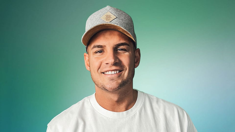 Foto für das Event Pietro Lombardi & Band mit dem Künstler mit einer Kappe vor grünem Hintergrund