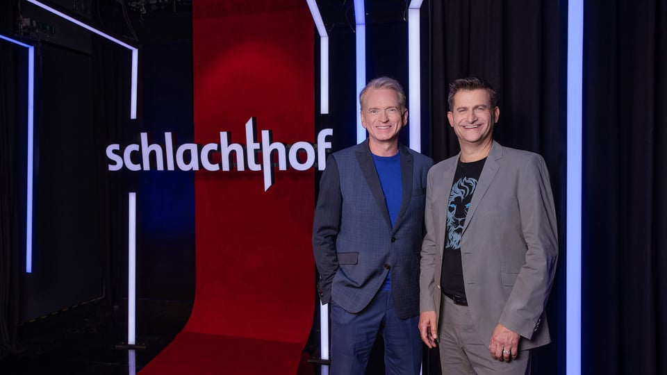 Zwei Moderatoren vor einer Tafel "Schlachthof"