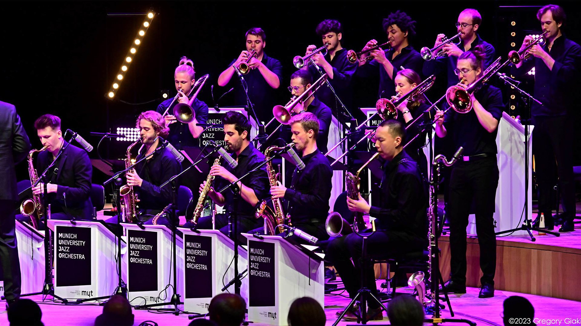 Foto für das Konzert ‚Abschlusskonzert des 16. Internationalen Jazzworkshops‘ mit einem Bild des Orchesters mit Blasinstrumenten, das auf einer Bühne spielt