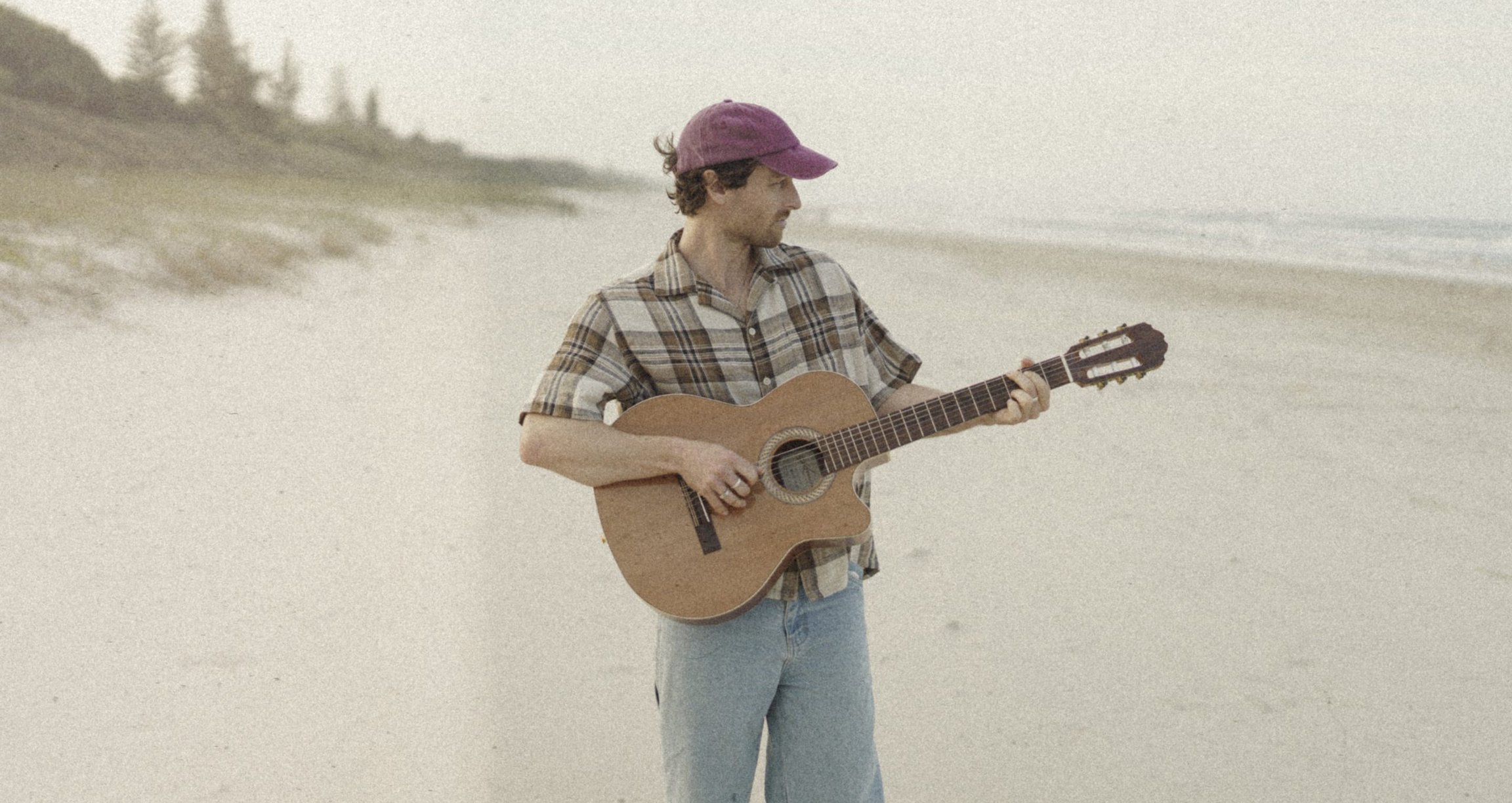 Harrison Storm mit Western-Gitarre am Strand