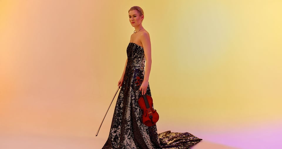Eine Frau in einem langen, sehr eleganten Kleid mit einem Instrument in der Hand, vor einem Hintergrund in Gelb, Rosa und Orange