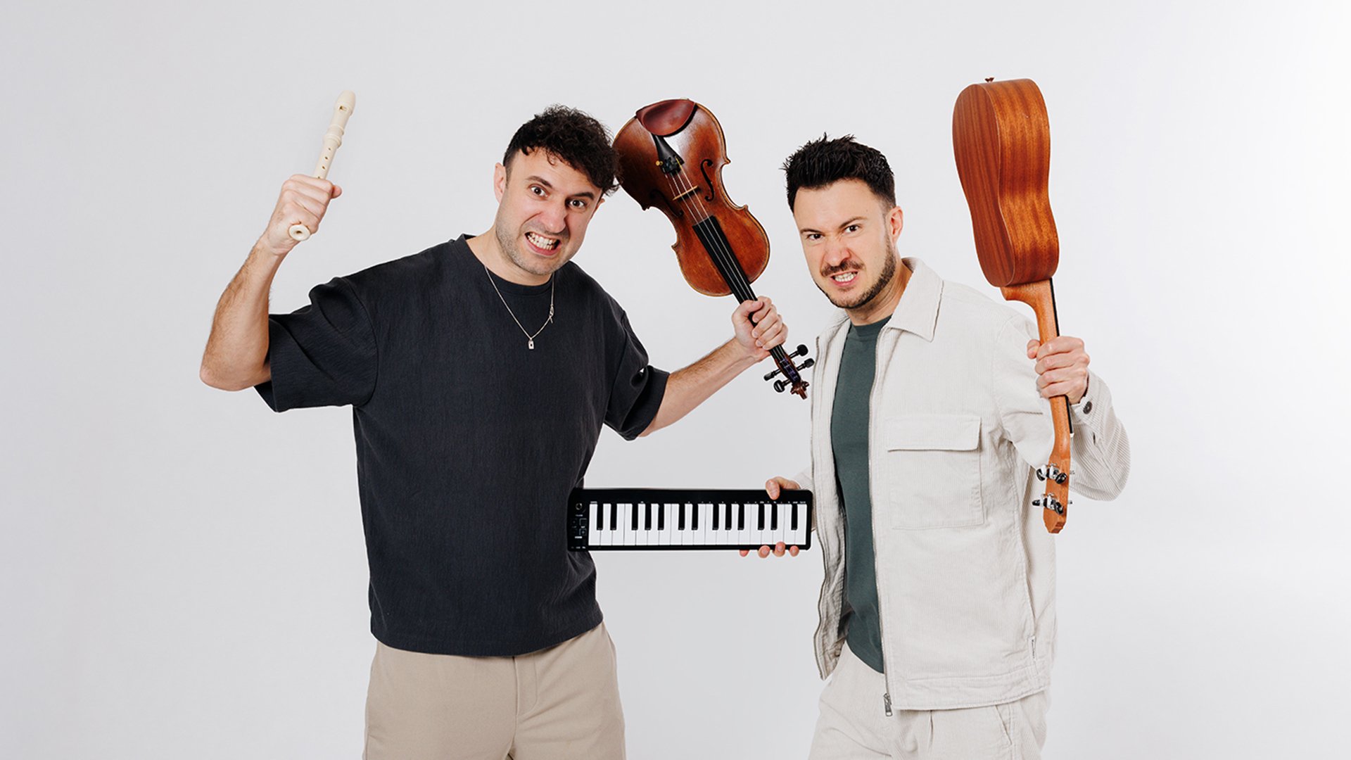 Die beiden Künstler mit Instrumenten vor weißem Hintergrund